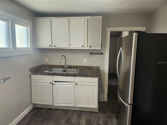 3415 N 51st St, Tampa, FL 33619 - kitchen featuring freestanding refrigerator, a sink, white cabinetry, dark wood-style floors, and dark countertops