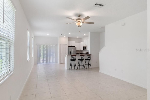 8305 Crescent Oaks Dr, New Port Richey, FL 34655 - kitchen featuring stainless steel appliances, ceiling fan, a breakfast bar, white cabinets, and open floor plan