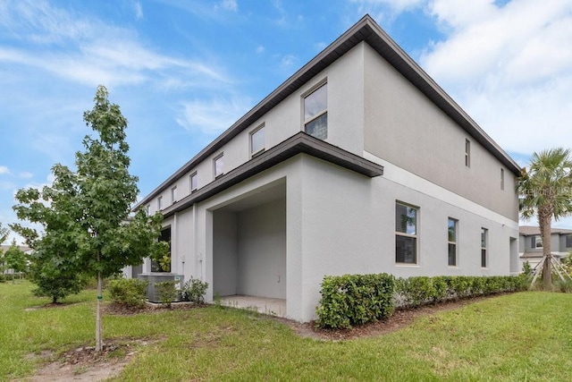 8305 Crescent Oaks Dr, New Port Richey, FL 34655 - view of side of property with stucco siding and a yard