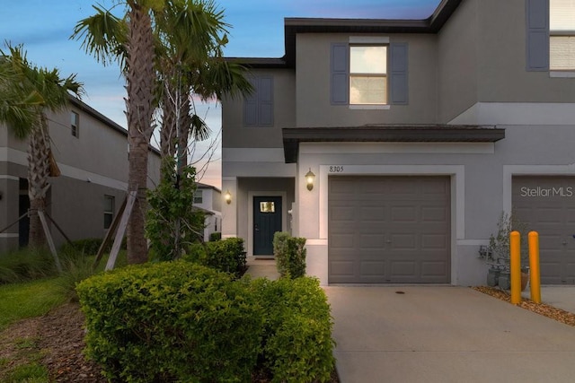 8305 Crescent Oaks Dr, New Port Richey, FL 34655 - view of front of home with stucco siding, concrete driveway, and an attached garage
