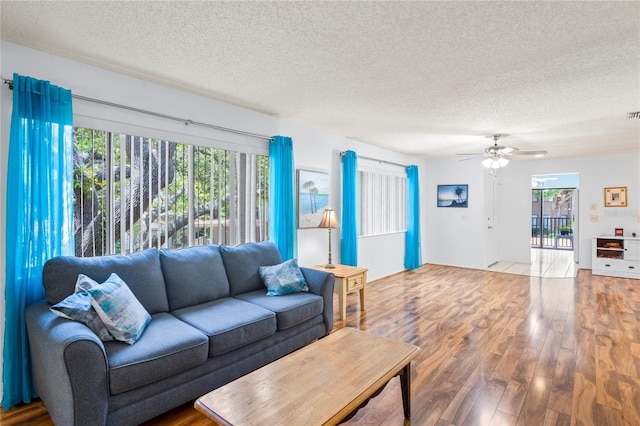 13009 Wedgewood Way Unit 63-D, Hudson, FL 34667 - living room with a textured ceiling, wood finished floors, and a ceiling fan