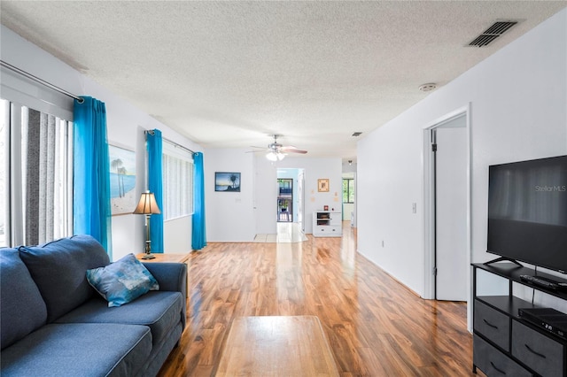 13009 Wedgewood Way Unit 63-D, Hudson, FL 34667 - living room featuring a textured ceiling, wood finished floors, and ceiling fan