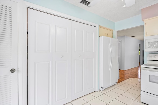 13009 Wedgewood Way Unit 63-D, Hudson, FL 34667 - kitchen featuring white appliances, light tile patterned flooring, cream cabinets, and light countertops