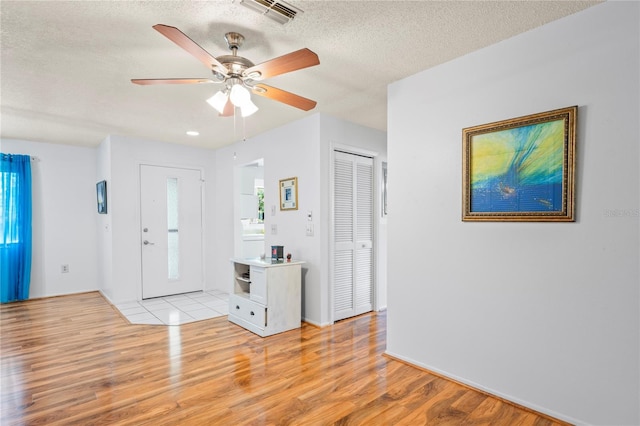 13009 Wedgewood Way Unit 63-D, Hudson, FL 34667 - entryway with light wood-style flooring, a ceiling fan, and a textured ceiling