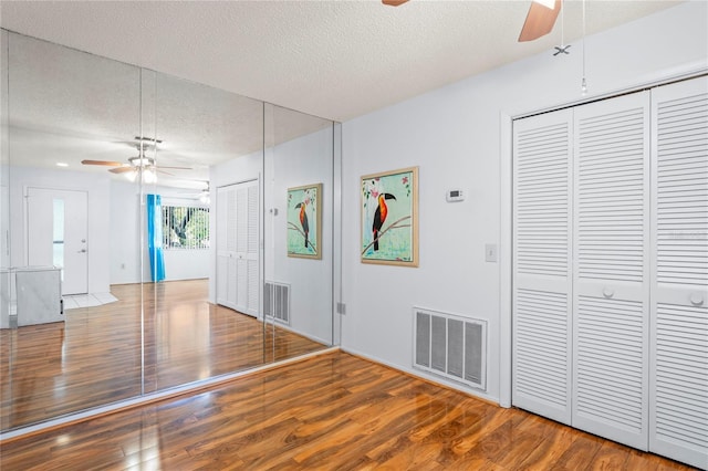 13009 Wedgewood Way Unit 63-D, Hudson, FL 34667 - unfurnished living room featuring a ceiling fan, a textured ceiling, and wood finished floors