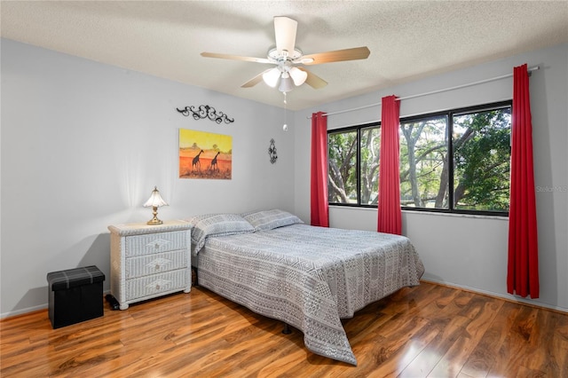 13009 Wedgewood Way Unit 63-D, Hudson, FL 34667 - bedroom with wood finished floors, a textured ceiling, and a ceiling fan