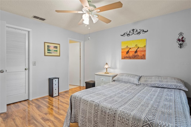 13009 Wedgewood Way Unit 63-D, Hudson, FL 34667 - bedroom featuring light wood-style flooring, a textured ceiling, and ceiling fan