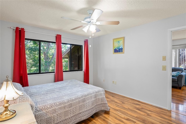 13009 Wedgewood Way Unit 63-D, Hudson, FL 34667 - bedroom featuring wood finished floors, a textured ceiling, and a ceiling fan
