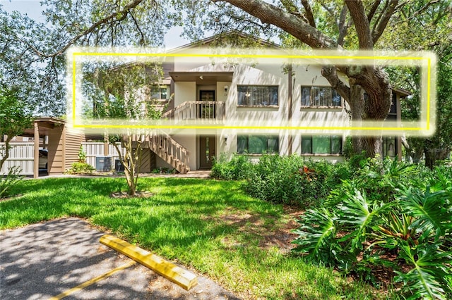 13009 Wedgewood Way Unit 63-D, Hudson, FL 34667 - view of front of home with stairs, uncovered parking, a front yard, and stucco siding