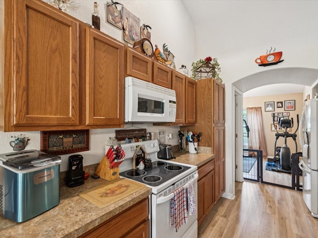 12229 Barnevelde Rd, Weeki Wachee, FL 34614 - kitchen with white appliances, arched walkways, brown cabinetry, and light countertops