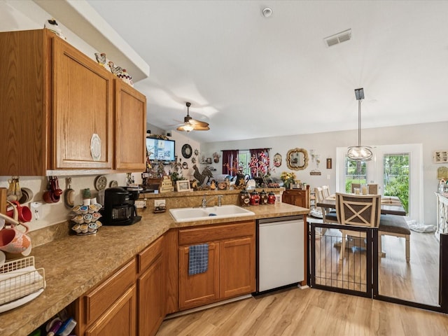 12229 Barnevelde Rd, Weeki Wachee, FL 34614 - kitchen with dishwashing machine, a sink, a peninsula, ceiling fan, and light wood-style flooring