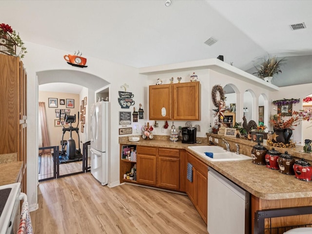 12229 Barnevelde Rd, Weeki Wachee, FL 34614 - kitchen featuring a sink, white appliances, brown cabinetry, light wood-type flooring, and light countertops