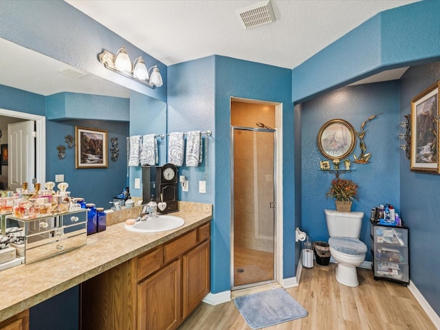 12229 Barnevelde Rd, Weeki Wachee, FL 34614 - bathroom with wood finished floors, a stall shower, toilet, vanity, and a textured wall