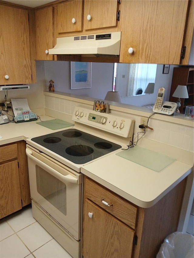 6050 Chesham Dr Unit 3, New Port Richey, FL 34653 - kitchen featuring white range with electric cooktop, under cabinet range hood, and brown cabinetry