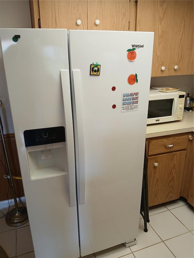 6050 Chesham Dr Unit 3, New Port Richey, FL 34653 - kitchen with white appliances, light tile patterned floors, brown cabinetry, and light countertops