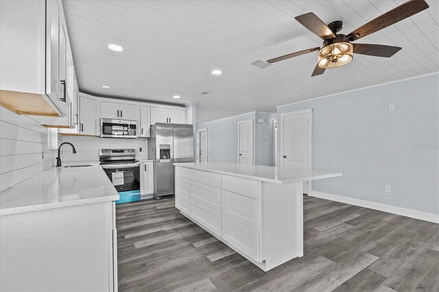 13821 Judy Ave, Hudson, FL 34667 - kitchen with stainless steel appliances, a sink, recessed lighting, a kitchen island, and white cabinetry