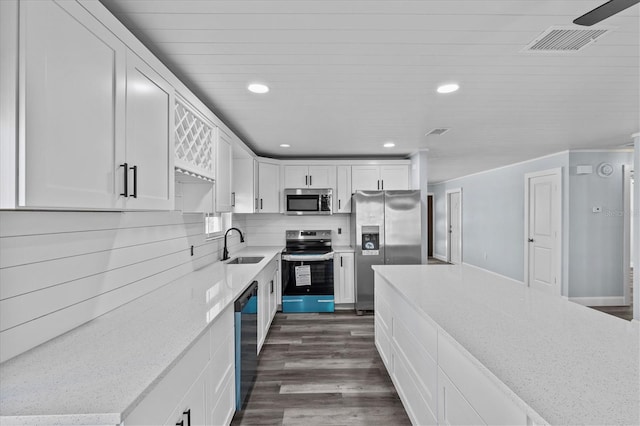 13821 Judy Ave, Hudson, FL 34667 - kitchen with stainless steel appliances, a sink, dark wood-style flooring, white cabinets, and recessed lighting
