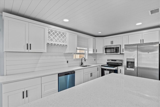 13821 Judy Ave, Hudson, FL 34667 - kitchen with appliances with stainless steel finishes, a sink, white cabinets, recessed lighting, and light stone countertops