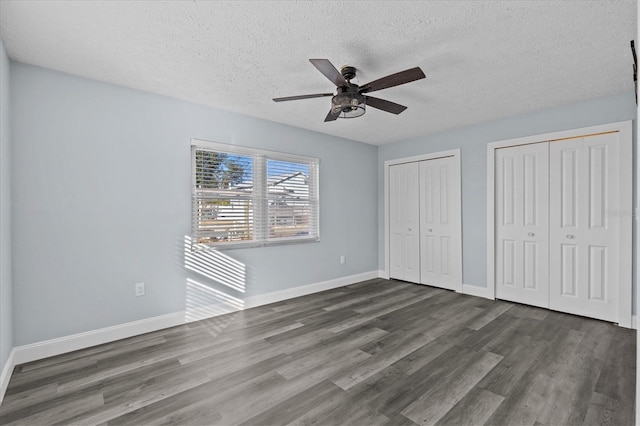 13821 Judy Ave, Hudson, FL 34667 - unfurnished bedroom featuring multiple closets, wood finished floors, a textured ceiling, and baseboards