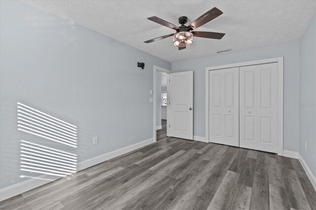 13821 Judy Ave, Hudson, FL 34667 - unfurnished bedroom featuring wood finished floors, baseboards, a closet, a textured ceiling, and a ceiling fan