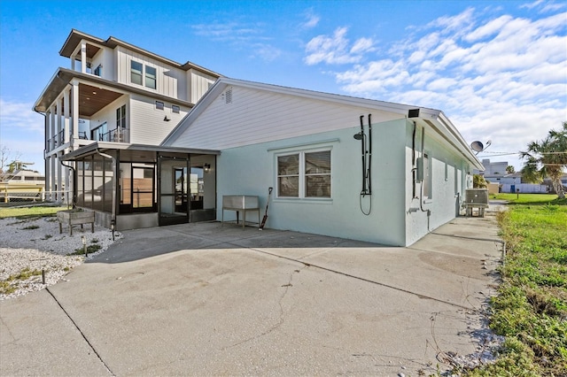13821 Judy Ave, Hudson, FL 34667 - back of property featuring a sunroom, a balcony, and stucco siding