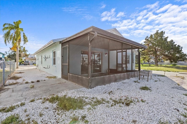 13821 Judy Ave, Hudson, FL 34667 - rear view of house featuring a sunroom and stucco siding