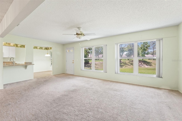 1415 Pinewood Hills Ct, Spring Hill, FL 34606 - unfurnished living room featuring a textured ceiling, ceiling fan, and light carpet