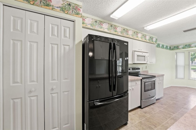 1415 Pinewood Hills Ct, Spring Hill, FL 34606 - kitchen featuring freestanding refrigerator, white microwave, stainless steel range with electric stovetop, a textured ceiling, and white cabinetry