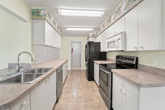 1415 Pinewood Hills Ct, Spring Hill, FL 34606 - kitchen with appliances with stainless steel finishes, a textured ceiling, white cabinets, and light countertops