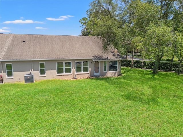 1415 Pinewood Hills Ct, Spring Hill, FL 34606 - rear view of property with a yard, a shingled roof, and stucco siding