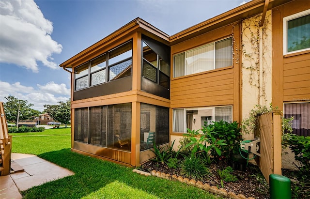 3841 Lanyard Ct Unit B, New Port Richey, FL 34652 - rear view of house with a lawn and a sunroom