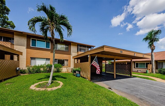 3841 Lanyard Ct Unit B, New Port Richey, FL 34652 - view of front of home featuring stucco siding, a front lawn, asphalt driveway, and a carport