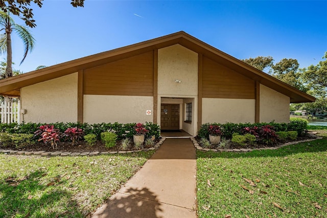 3841 Lanyard Ct Unit B, New Port Richey, FL 34652 - doorway to property featuring stucco siding and a yard