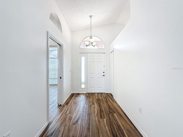 3317 Abigail Ct, New Port Richey, FL 34655 - foyer with dark wood-style floors, vaulted ceiling, a textured ceiling, and a chandelier