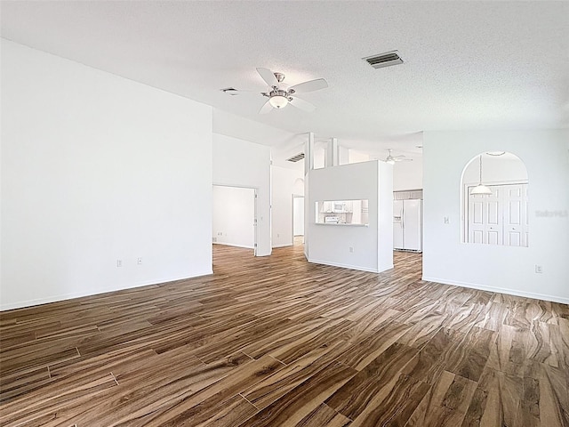 3317 Abigail Ct, New Port Richey, FL 34655 - unfurnished living room featuring ceiling fan, wood finished floors, lofted ceiling, and a textured ceiling