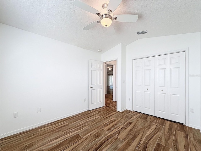 3317 Abigail Ct, New Port Richey, FL 34655 - unfurnished bedroom with dark wood-style floors, vaulted ceiling, a textured ceiling, a closet, and ceiling fan