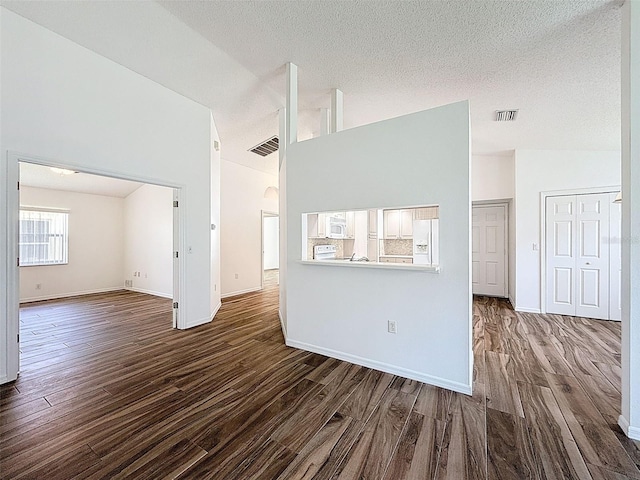 3317 Abigail Ct, New Port Richey, FL 34655 - unfurnished living room with dark wood finished floors, high vaulted ceiling, a textured ceiling, and arched walkways