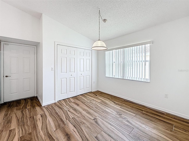 3317 Abigail Ct, New Port Richey, FL 34655 - unfurnished bedroom featuring a textured ceiling, wood finished floors, a closet, and lofted ceiling