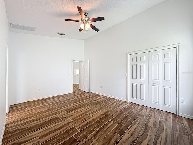 3317 Abigail Ct, New Port Richey, FL 34655 - unfurnished bedroom with dark wood-style flooring, a closet, ceiling fan, a textured ceiling, and high vaulted ceiling