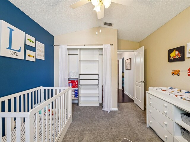 4716 Wolfram Ln, New Port Richey, FL 34653 - carpeted bedroom featuring vaulted ceiling, a crib, a textured ceiling, and ceiling fan