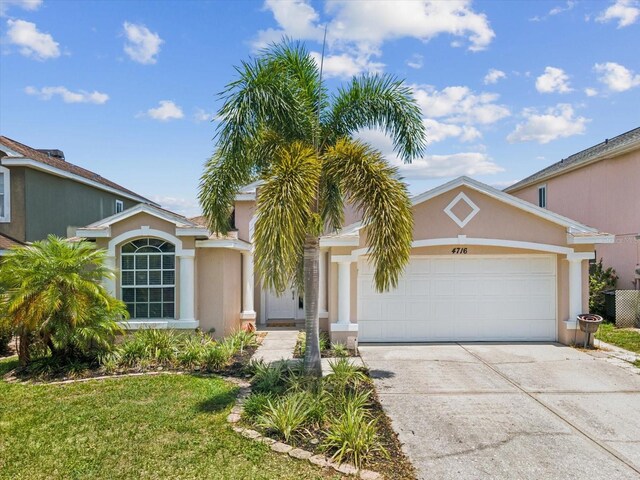 4716 Wolfram Ln, New Port Richey, FL 34653 - view of front of property featuring an attached garage, concrete driveway, and stucco siding