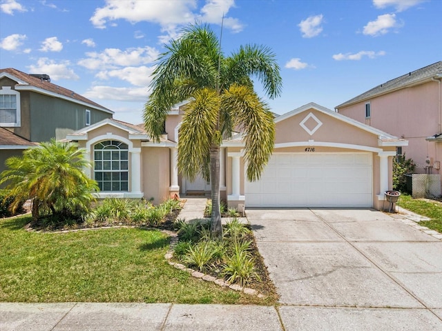 4716 Wolfram Ln, New Port Richey, FL 34653 - view of front of home with a garage, concrete driveway, a front yard, and stucco siding