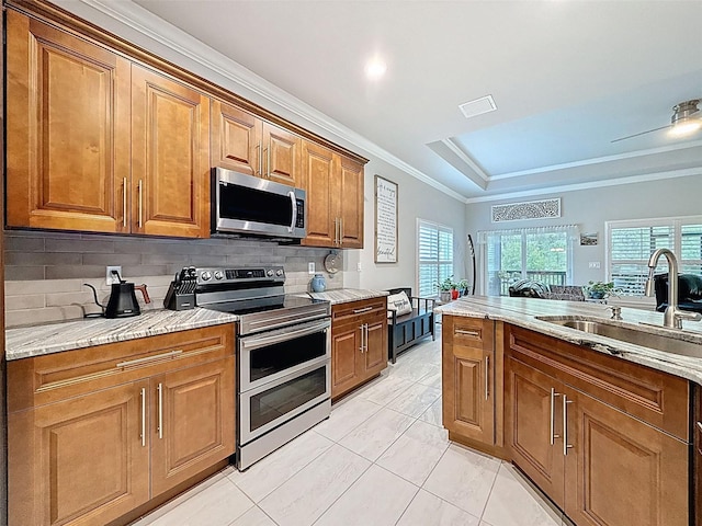 4082 Watson Dr, New Port Richey, FL 34655 - kitchen featuring stainless steel appliances, brown cabinets, decorative backsplash, light stone countertops, and crown molding