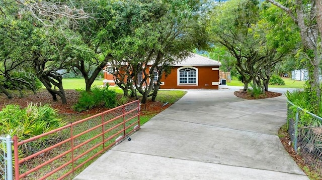9130 Madrid Rd, Weeki Wachee, FL 34613 - view of property hidden behind natural elements featuring driveway and stucco siding
