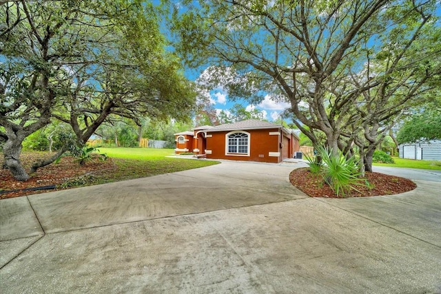 9130 Madrid Rd, Weeki Wachee, FL 34613 - view of front of house featuring curved driveway, a front lawn, and stucco siding