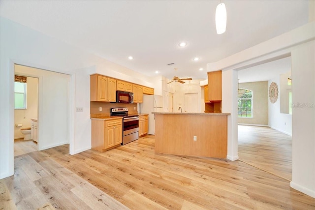 9130 Madrid Rd, Weeki Wachee, FL 34613 - kitchen with electric stove, freestanding refrigerator, black microwave, light wood-style floors, and recessed lighting
