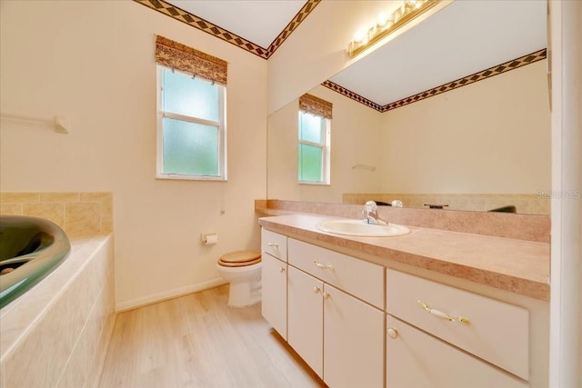 9130 Madrid Rd, Weeki Wachee, FL 34613 - bathroom with vanity, a relaxing tiled tub, crown molding, and wood finished floors