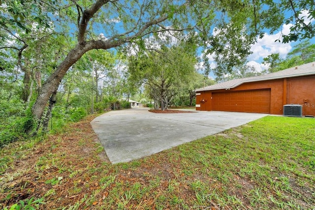 9130 Madrid Rd, Weeki Wachee, FL 34613 - view of green lawn with concrete driveway and a garage