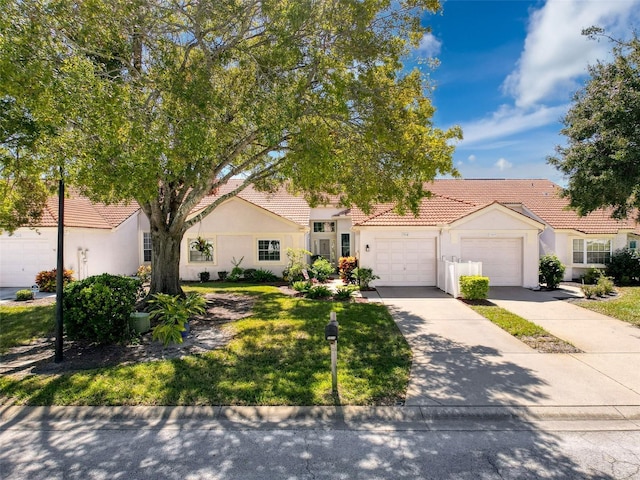 7518 Mediterranean Ct, Hudson, FL 34667 - view of front of property featuring stucco siding, a tiled roof, an attached garage, concrete driveway, and a front yard