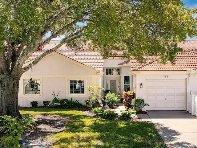 7518 Mediterranean Ct, Hudson, FL 34667 - view of front of house featuring stucco siding, an attached garage, driveway, and a tiled roof